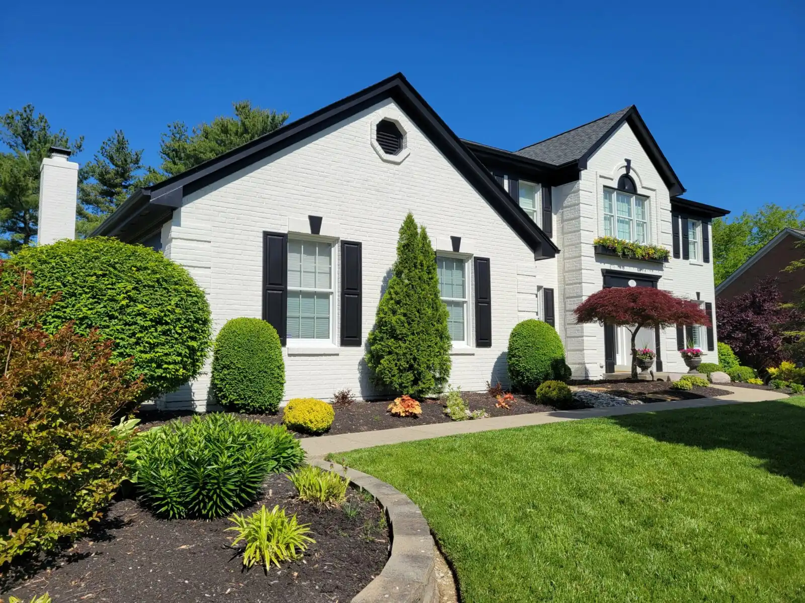 White two-story home with black shutters after an exterior repaint by Wichita House Painting